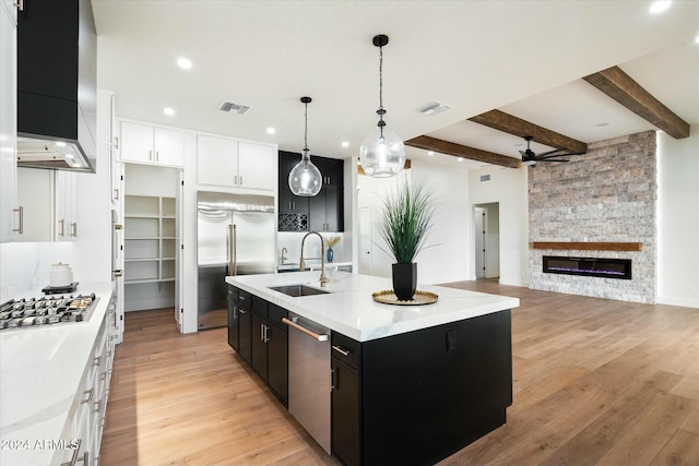 kitchen with dark cabinets, visible vents, stainless steel appliances, and a sink