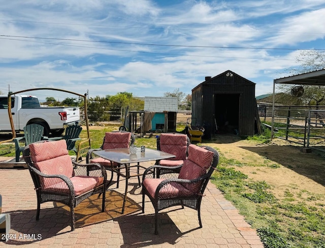 view of patio featuring outdoor dining space, an outbuilding, and a storage unit