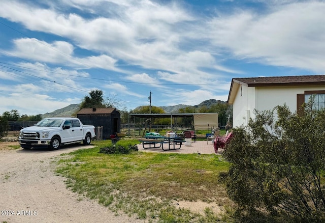 view of yard featuring an outdoor structure and a mountain view