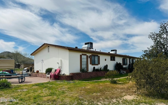 back of house featuring a patio area and a lawn