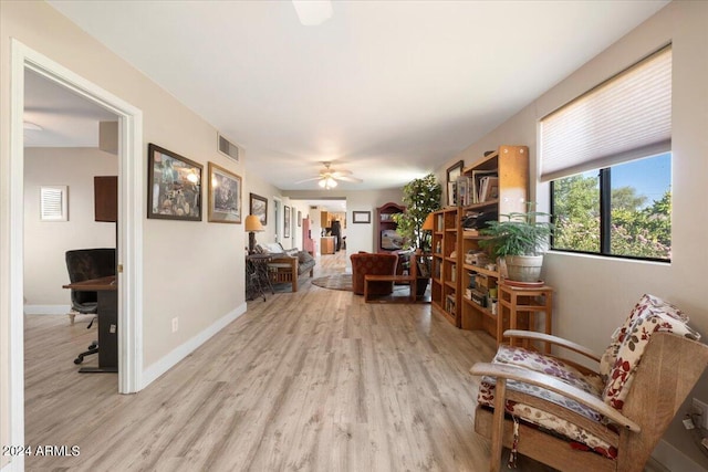 interior space with light wood-style flooring, baseboards, visible vents, and ceiling fan