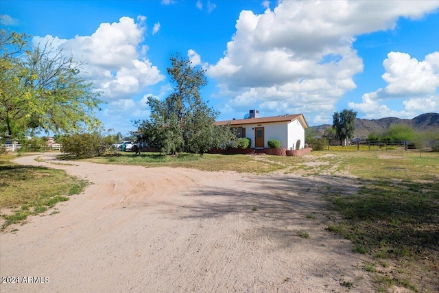 view of street with a rural view, a mountain view, and driveway