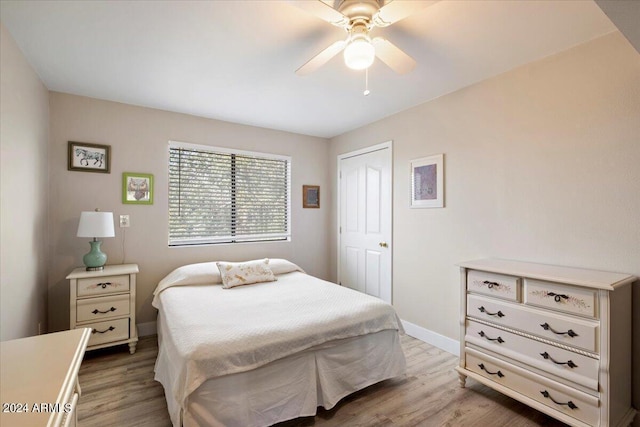 bedroom featuring baseboards, wood finished floors, and a ceiling fan