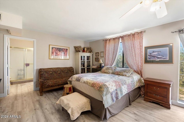 bedroom featuring ensuite bath, light wood-style flooring, and a ceiling fan