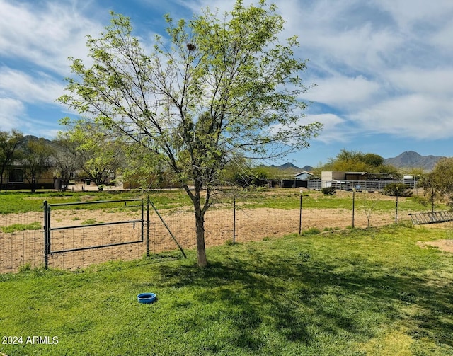 view of yard with a rural view, a mountain view, and fence