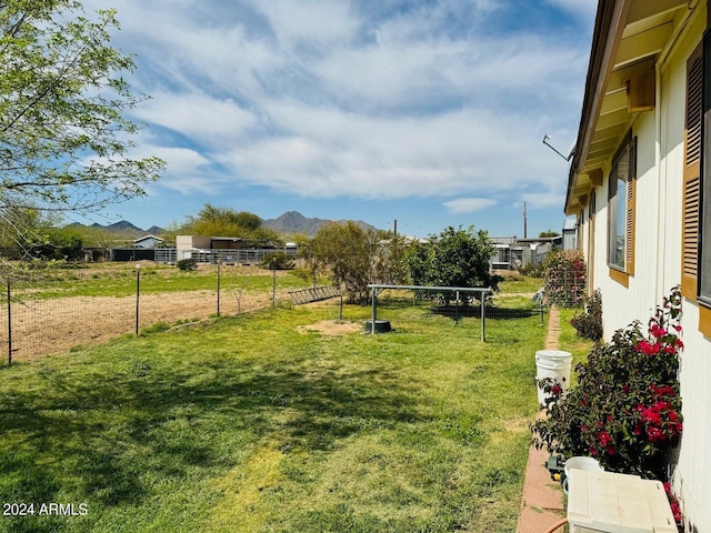 view of yard featuring a mountain view and fence