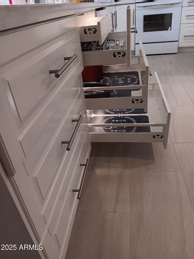 kitchen with white cabinetry and white electric range oven