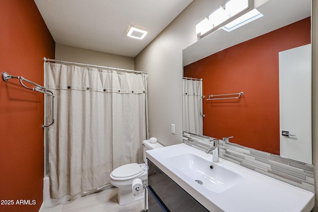 bathroom with toilet, tasteful backsplash, and vanity