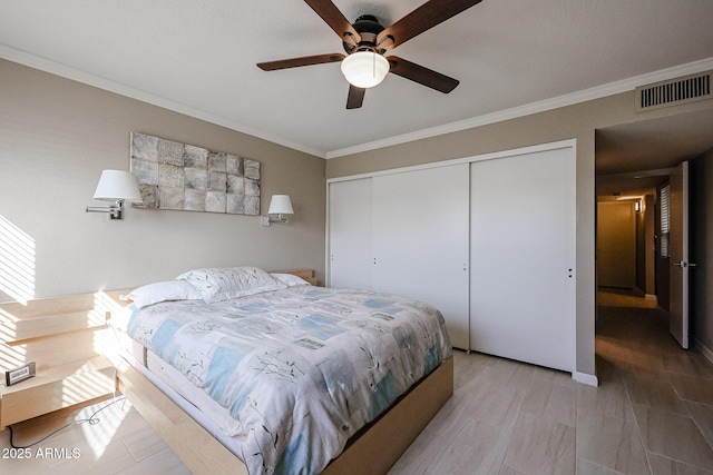 bedroom with ceiling fan, a closet, and ornamental molding