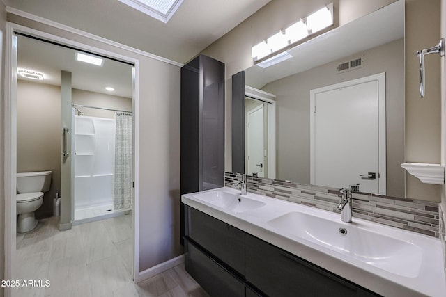 bathroom featuring toilet, vanity, decorative backsplash, and curtained shower