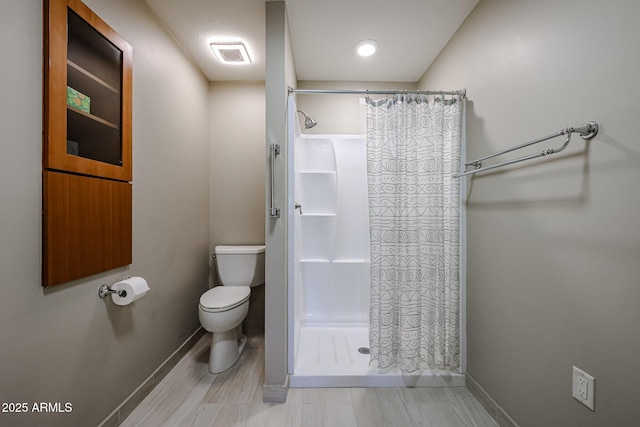 bathroom featuring toilet, a textured ceiling, and walk in shower