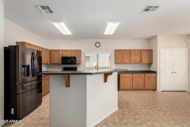 11511 E Renata Ave, Mesa, AZ 85212 - kitchen featuring black appliances, a breakfast bar, brown cabinets, and dark countertops
