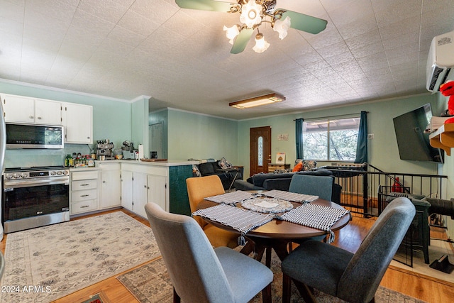 dining area featuring a wall mounted AC, light hardwood / wood-style floors, ceiling fan, and crown molding