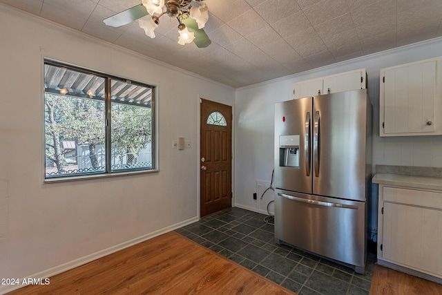 kitchen featuring stainless steel fridge, white cabinets, dark wood-style floors, ornamental molding, and light countertops