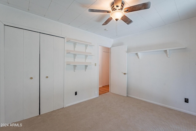 unfurnished bedroom featuring a closet, light carpet, and ceiling fan