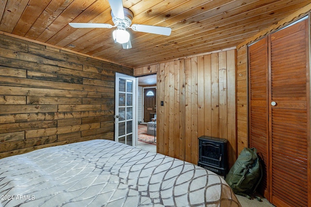 unfurnished bedroom featuring wooden ceiling, ceiling fan, and wooden walls