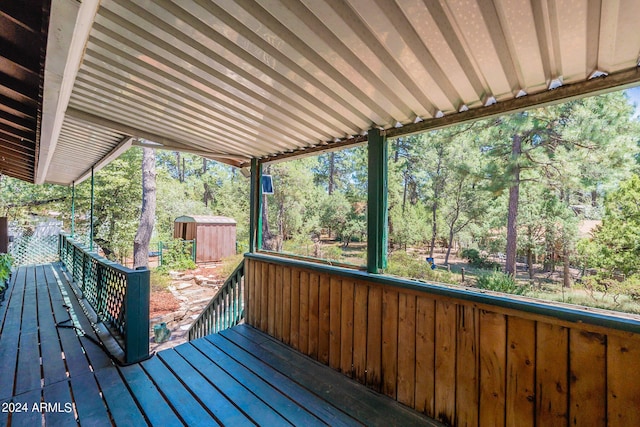 wooden deck with an outbuilding and a storage unit