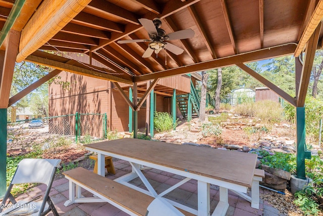 view of patio / terrace with stairway, ceiling fan, and fence