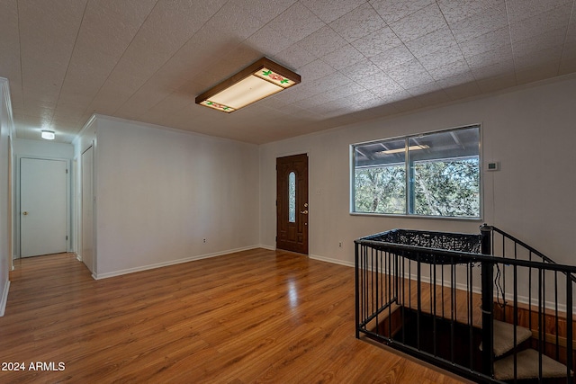 foyer entrance with wood finished floors and baseboards