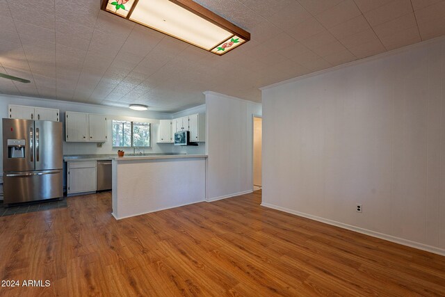 living room featuring light hardwood / wood-style floors, crown molding, and a wall mounted air conditioner