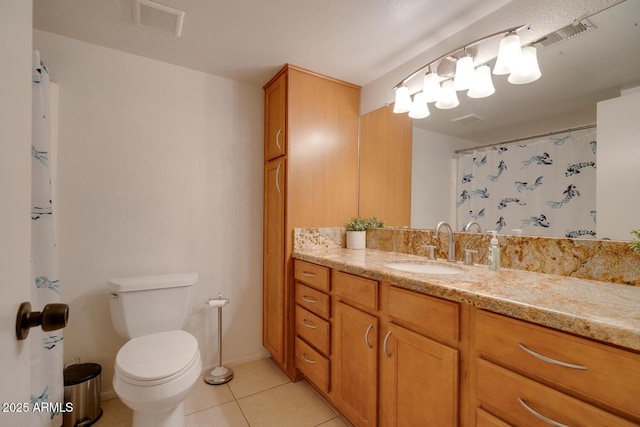 bathroom with tile patterned flooring, vanity, and toilet