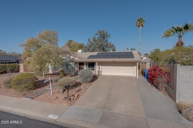 view of front of property featuring a garage and solar panels