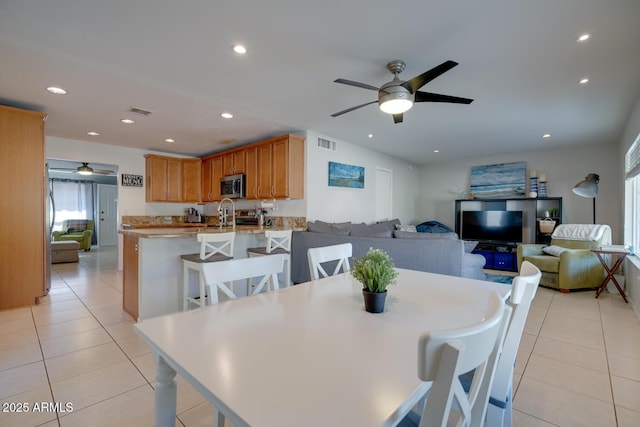 tiled dining room with sink and ceiling fan