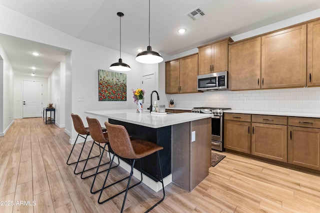 27510 N 30th Ln, Phoenix, AZ 85083 - kitchen featuring appliances with stainless steel finishes, light countertops, light wood finished floors, tasteful backsplash, and recessed lighting