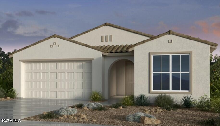 view of front of home featuring a garage, stucco siding, a tile roof, and concrete driveway