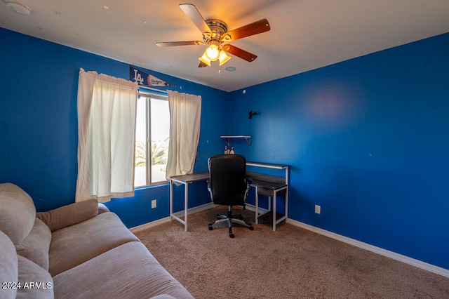 carpeted home office featuring ceiling fan