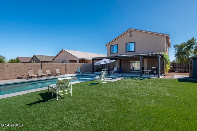 rear view of property featuring a patio, a yard, and a fenced in pool