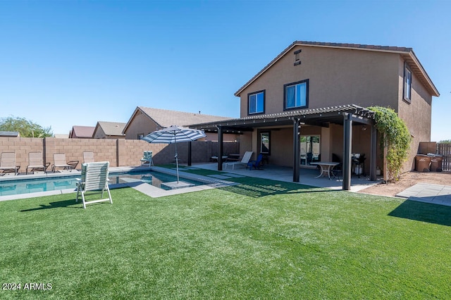 rear view of house featuring a swimming pool with hot tub, a lawn, and a patio