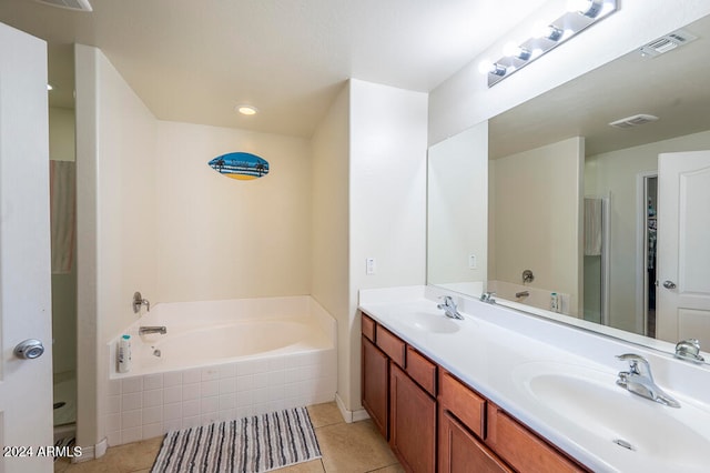 bathroom with vanity, tile patterned floors, and a relaxing tiled tub