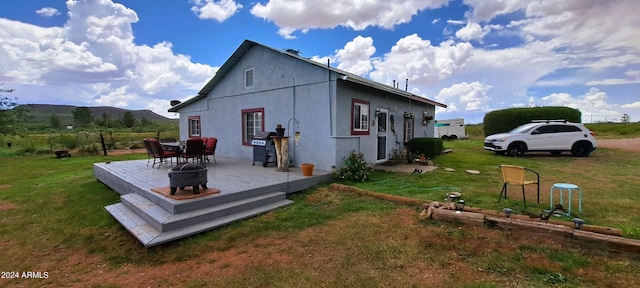 back of house with a patio area, a mountain view, and a yard