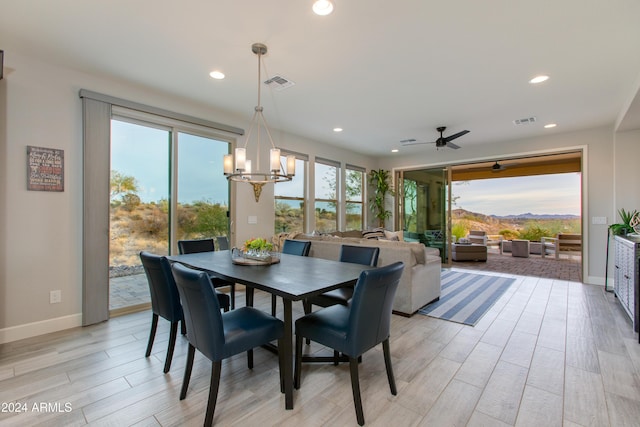 dining room featuring ceiling fan with notable chandelier and light wood-type flooring