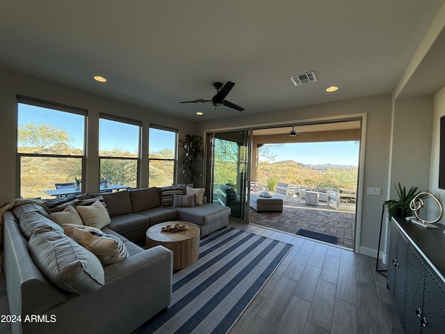 sunroom featuring a mountain view and ceiling fan