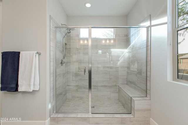 bathroom with plenty of natural light and a shower with shower door