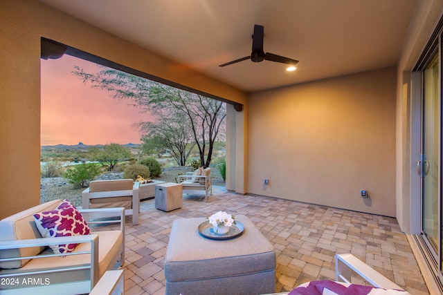 patio terrace at dusk with an outdoor living space and ceiling fan