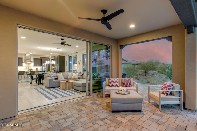 patio terrace at dusk with outdoor lounge area and ceiling fan