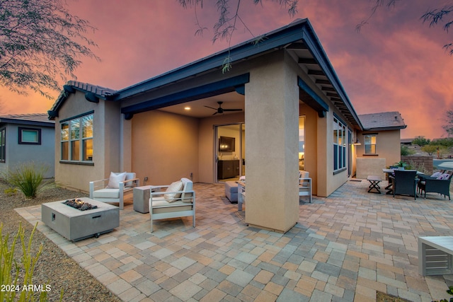 patio terrace at dusk featuring an outdoor living space with a fire pit