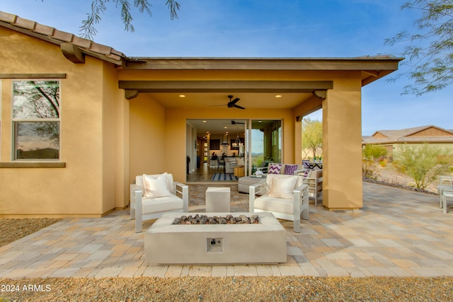 view of patio with ceiling fan and an outdoor living space with a fire pit