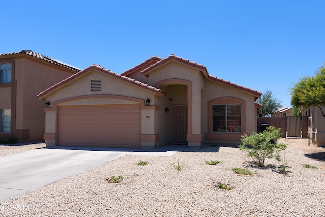 10649 W Monte Vista Rd, Avondale, AZ 85392 - mediterranean / spanish home with a garage, a tile roof, stucco siding, a gate, and driveway