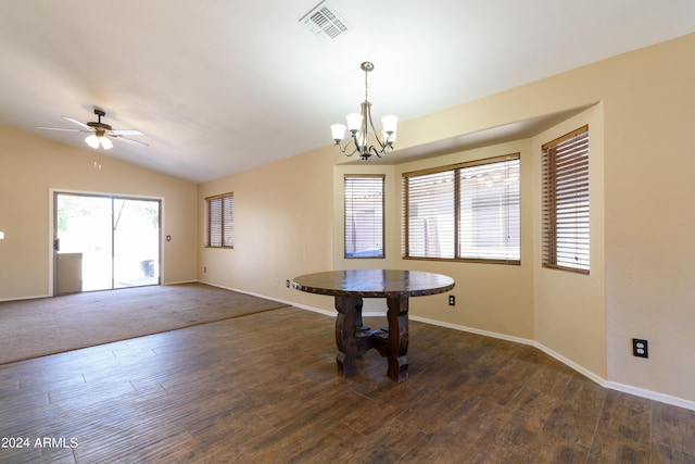 unfurnished dining area with ceiling fan with notable chandelier, dark wood-type flooring, and lofted ceiling