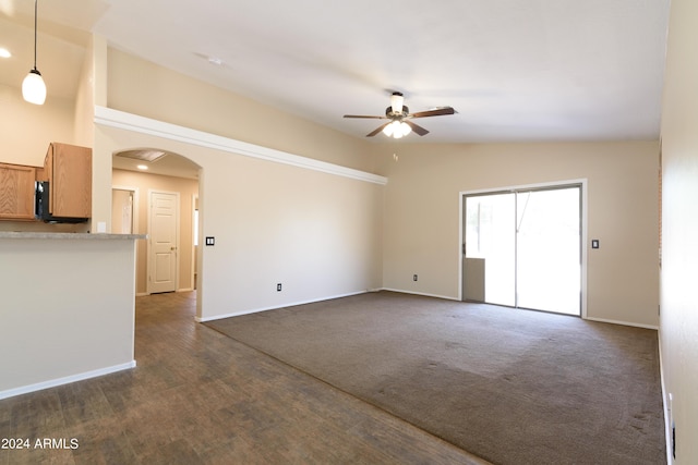 unfurnished living room with ceiling fan and vaulted ceiling