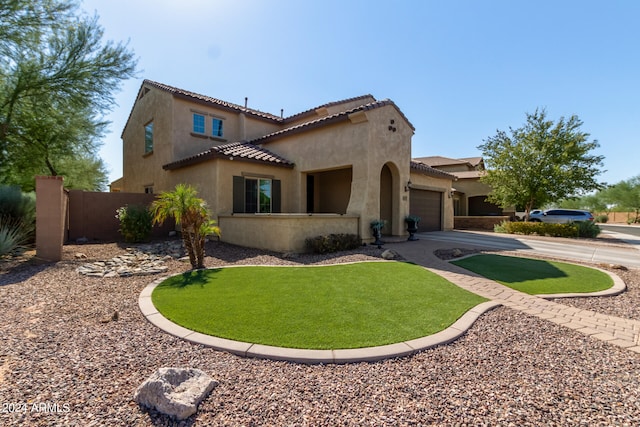 mediterranean / spanish house featuring a garage and a front lawn