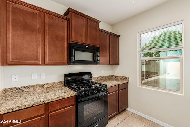 kitchen featuring black appliances, light tile patterned flooring, and light stone counters