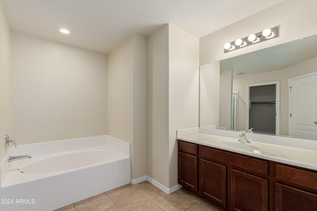 bathroom with tiled tub, tile patterned floors, and vanity