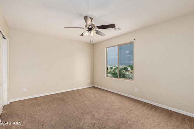 empty room featuring ceiling fan and carpet floors