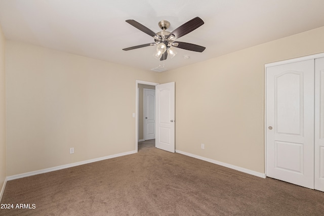 unfurnished bedroom with ceiling fan, carpet flooring, and a closet