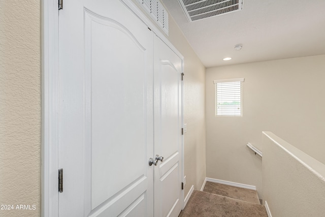 hallway featuring light colored carpet